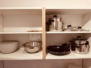 a kitchen shelf with pots and pans on it at FELIX LIVING 9, modern & cozy, 3 Zimmer Wohnung, Parkplatz in Salzweg +10 photos
