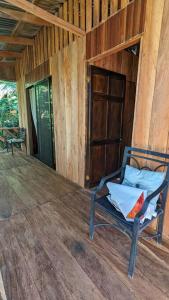una silla sentada en el porche de una cabaña en Cabaña entre montañas, equipada., en La Cruz