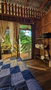 1 dormitorio con 1 cama en una habitación con ventana en Cabaña entre montañas, equipada., en La Cruz