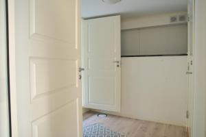 a closet with white doors and a rug at Spacious apartment in Sarpsborg