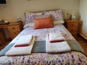a bed with two towels on top of it at Beech Lodge B&B in Lisheenanoran