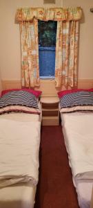 2 Betten in einem Zimmer mit Fenster in der Unterkunft Domek Jastarnia in Jastarnia