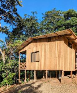 un gran edificio de madera con árboles en el fondo en Cabaña entre montañas, equipada., en La Cruz