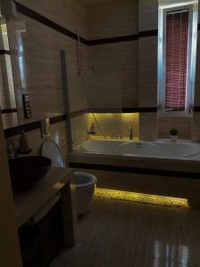 y baño con bañera, aseo y lavamanos. en Turzyn Apartament: Idealne miejsce na Twój wypoczynek, en Szczecin