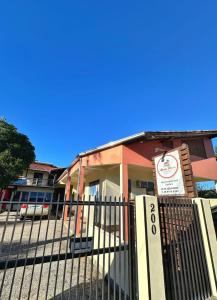 a building with a fence in front of it at Pousada Areia Nova in Garopaba