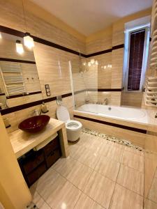a bathroom with a tub and a toilet and a sink at Turzyn Apartament: Idealne miejsce na Twój wypoczynek in Szczecin