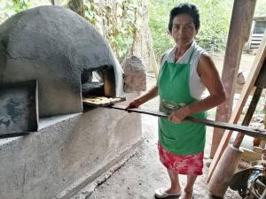 a woman is holding a stick in front of an oven at Landscape-Cabaña Summer-Full Equipada in La Cruz