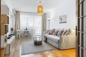 a living room with a couch and a table at Unirii Green Apartment in Bucharest