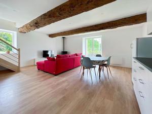 sala de estar con sofá rojo y mesa en La Villa Coudray - Au Calme - Spacieuse, en Chavagne