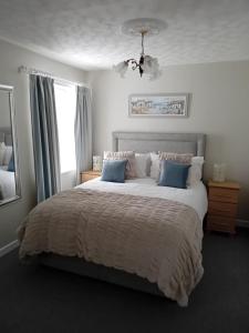 a bedroom with a large white bed with blue pillows at Ocean View in Bushmills