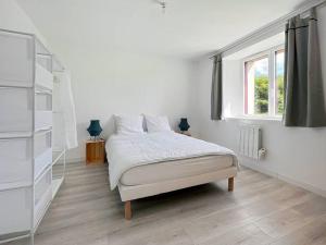 een witte slaapkamer met een bed en een raam bij La Villa Coudray - Au Calme - Spacieuse in Chavagne