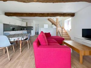 een woonkamer met een rode bank en een tafel bij La Villa Coudray - Au Calme - Spacieuse in Chavagne