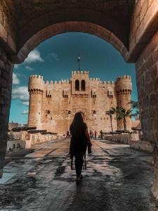 une femme marchant devant un château dans l'établissement LOTUS HOLIDAY TOURS, au Caire