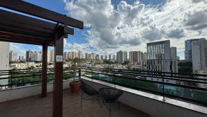een balkon met 2 stoelen en uitzicht op de stad bij Monte Carmel in Ribeirão Preto