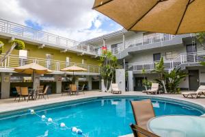 una piscina di fronte a un hotel con sedie e ombrelloni di Baja Inn Hoteles La Mesa a Tijuana