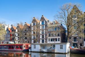 a house boat in the water in front of buildings at Storehouse Studios in Amsterdam