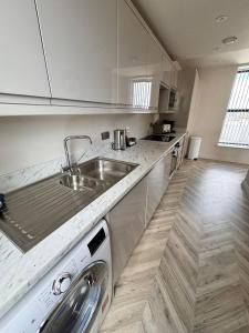 cocina con fregadero y lavavajillas en 2 Bedroom City Centre Penthouse en Leeds