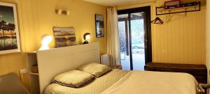 a bedroom with a bed with a pillow on it at Tres belle maison en bois,dans la Marina, 10pers, au bord de leau in Lacanau +57 photos