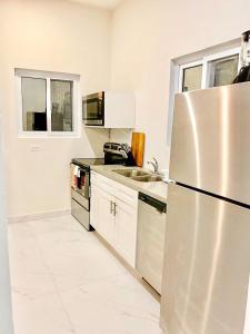 La cuisine est équipée d'un réfrigérateur en acier inoxydable et d'un évier. dans l'établissement Jimmy Hill Beach Villa No 2, à Jimmy Hill