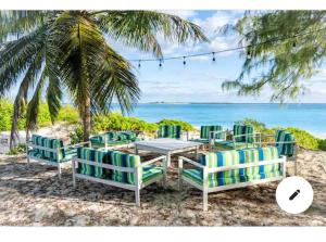 - un groupe de chaises et une table sur la plage dans l'établissement Jimmy Hill Beach Villa No 2, à Jimmy Hill