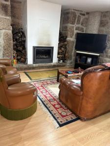 a living room with two chairs and a fireplace at Quinta de São Martinho - Visconde do Penedo in Caniçada