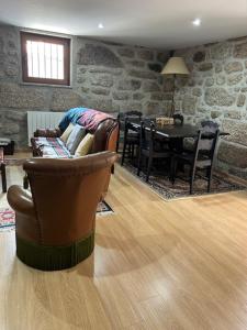 a living room with a leather chair and a table at Quinta de São Martinho - Visconde do Penedo in Caniçada