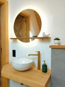 a bathroom with a bowl sink and a mirror at Domki Hygge Tatra Luxury Chalet in Murzasichle