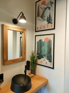 ein Badezimmer mit einem Waschbecken und einem Spiegel auf dem Schreibtisch in der Unterkunft Domki Hygge Tatra Luxury Chalet in Murzasichle