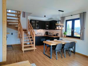 a kitchen and dining room with a wooden table and chairs at Hygge Tatra Luxury Chalet - Domki z Balią in Murzasichle