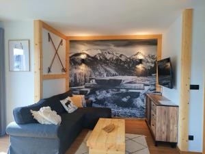 sala de estar con sofá y una foto en la pared en Domki Hygge Tatra Luxury Chalet, en Murzasichle