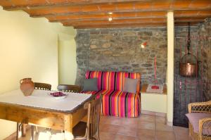 a dining room with a table and a couch at CAL JOAN pallars in Salás de Pallás