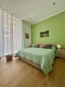 D'Aragona Guest House في باليرمو: غرفة نوم خضراء بسرير ونافذة كبيرة