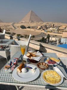 d'une table avec de la nourriture et une vue sur les pyramides dans l'établissement LOTUS HOLIDAY TOURS, au Caire