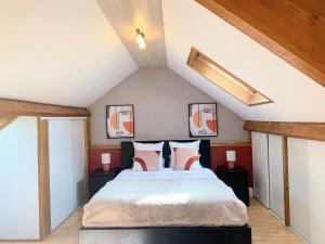 a bedroom with a large bed in a attic at COQUELICOT - Spacieuse maison 172m2 - 4 chambres - Parking Privé & Wifi Gratuit in Brunoy