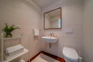 uma casa de banho branca com um lavatório e um WC em Old Town Seabreeze Residence em Rovinj