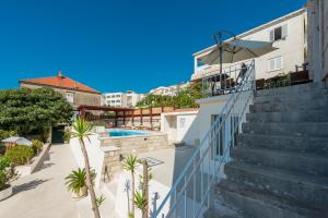 a stairway leading up to a building with palm trees at Apartments Miljas 2 in Dubrovnik