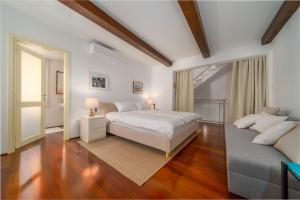 um quarto branco com uma cama e um sofá em Old Town Seabreeze Residence em Rovinj
