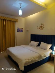 1Bedroom Furnished Apartment في دبي: غرفة نوم بسرير كبير عليها شراشف ووسائد بيضاء