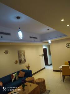 1Bedroom Furnished Apartment في دبي: غرفة معيشة مع أريكة زرقاء وطاولة