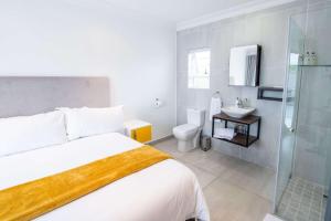 a bedroom with a bed and a shower and a sink at Le Rubis Guesthouse in Van Riebeekhoogte