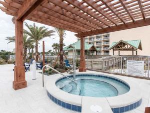 a hot tub with a pergola on a patio at blu #606 Luxury 2 Bd Beachfront Condo in Fort Walton Beach