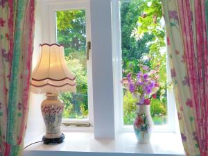uma lâmpada sentada numa mesa ao lado de dois vasos em Ferienhaus für 2 Personen und 1 Kind in Slaithwaite, England West Yorkshire em Slaithwaite