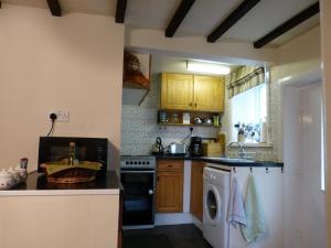 a kitchen with a stove and a dishwasher at Ferienhaus für 2 Personen und 1 Kind in Slaithwaite, England West Yorkshire in Slaithwaite