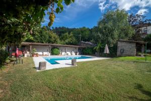 奧倫塞的住宿－Aloumiños do Ribeiro，一座带房子的庭院内的游泳池