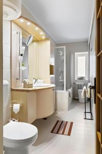 a bathroom with a toilet and a sink at Unirii Green Apartment in Bucharest +18 photos