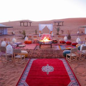 una tenda in mezzo al deserto con un tappeto rosso di Luxury berber style a Merzouga
