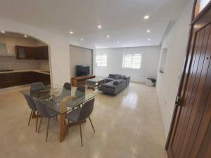 ein Wohnzimmer mit einem Tisch, Stühlen und einem Sofa in der Unterkunft Spacious, Central & New 3-BR apartment. Wifi & AC in Is-Swieqi