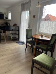 a living room with a table and chairs and a window at Ferienwohnung am Nordpfad Zevener Geest in Zeven