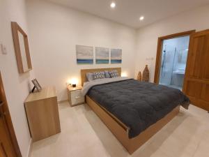 a bedroom with a large bed and a bathroom at Spacious, Central & New 3-BR apartment. Wifi & AC in Is-Swieqi