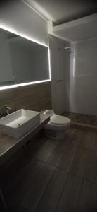 a bathroom with a sink and a toilet and a mirror at RENTSUITE Los Pinos 165 in Tarapoto